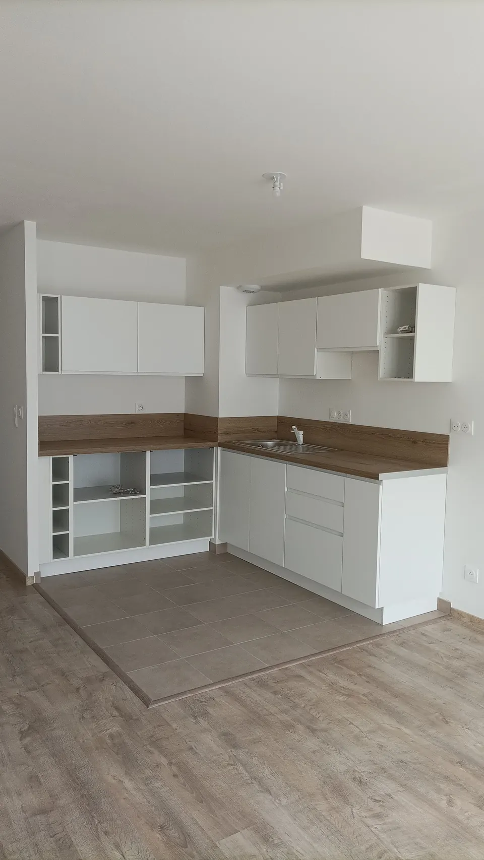 Création d'une cuisine blanche en angle sur mesure pour un appartement